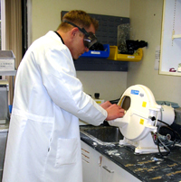 Christopher Beadle works on a patient's dental impression using a model trimmer.