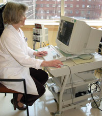 Christy Ludlow uses an electromyograph monitor to study muscle activity in the throat.