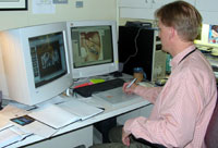 Don Bliss works views medical illustrations he is working on at his desk.