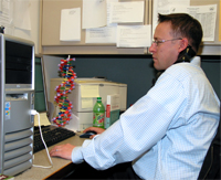 At his desk, Geoff takes calls from the media and answers questions about NHGRI research and other resources.