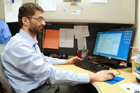 Ilias Alevizos sits at his desk to check email, review data and analyze experimental results.