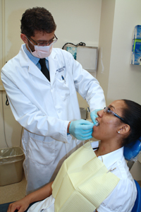 In the clinic, Ilias Alevizos collects saliva from a patient.
