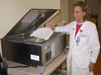 Karen Ullman places material for modeling a patient's head into a heated water bath so that it can be used to make an immobilization mask.