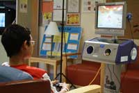 A young NCI patient spends some free time playing a game in a Clinical Center recreation room.