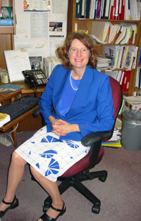 Lynne Haverkos is surrounded by many of the books, research journals, and documents she uses for the research grant review process.