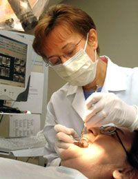 Mary Walker conducts an intra-oral examination on a dental patient.