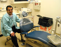 Sunil sits at the head of a typical reclining chair used in an orthodonics clinic