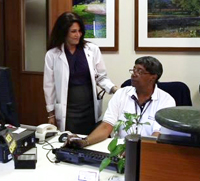 Yvonne questions a colleague about the schedule of patients for the day.