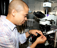 Zayd adjusts a glass pipette to set up for running an electrophysiology experiment.